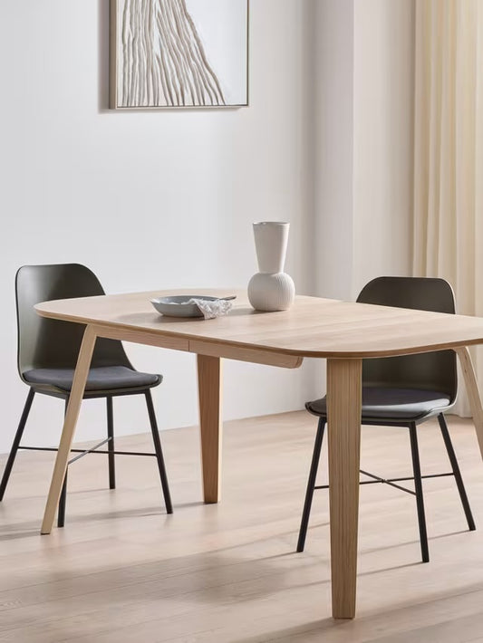 John Lewis ANYDAY Anton 6-8 seater extending dining table in light oak, featuring a curved rectangular top and four tapered wooden legs on a plain background.