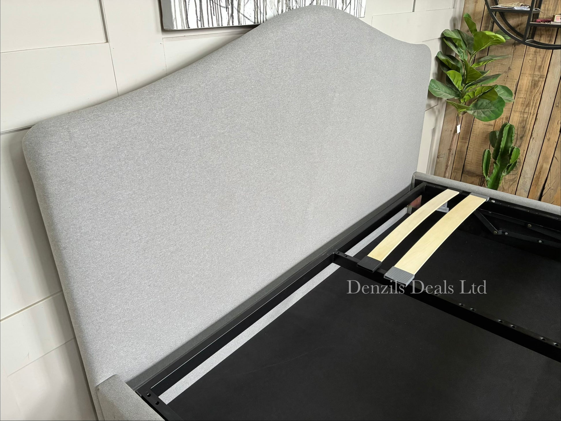 John Lewis Alice Super King ottoman bed frame in Cotton Effect Grey. The bed features a foam-filled, curved headboard with fine-textured grey upholstery and an integrated lifting base for under-bed storage.