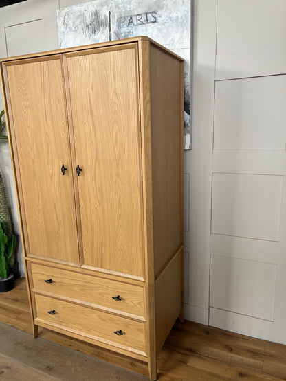 Freestanding John Lewis Bevel Double Wardrobe in a natural light oak finish, featuring two hinged doors with minimalist metal handles, two spacious storage drawers at the base, and distinctive beveled detailing along the edges and plinth.