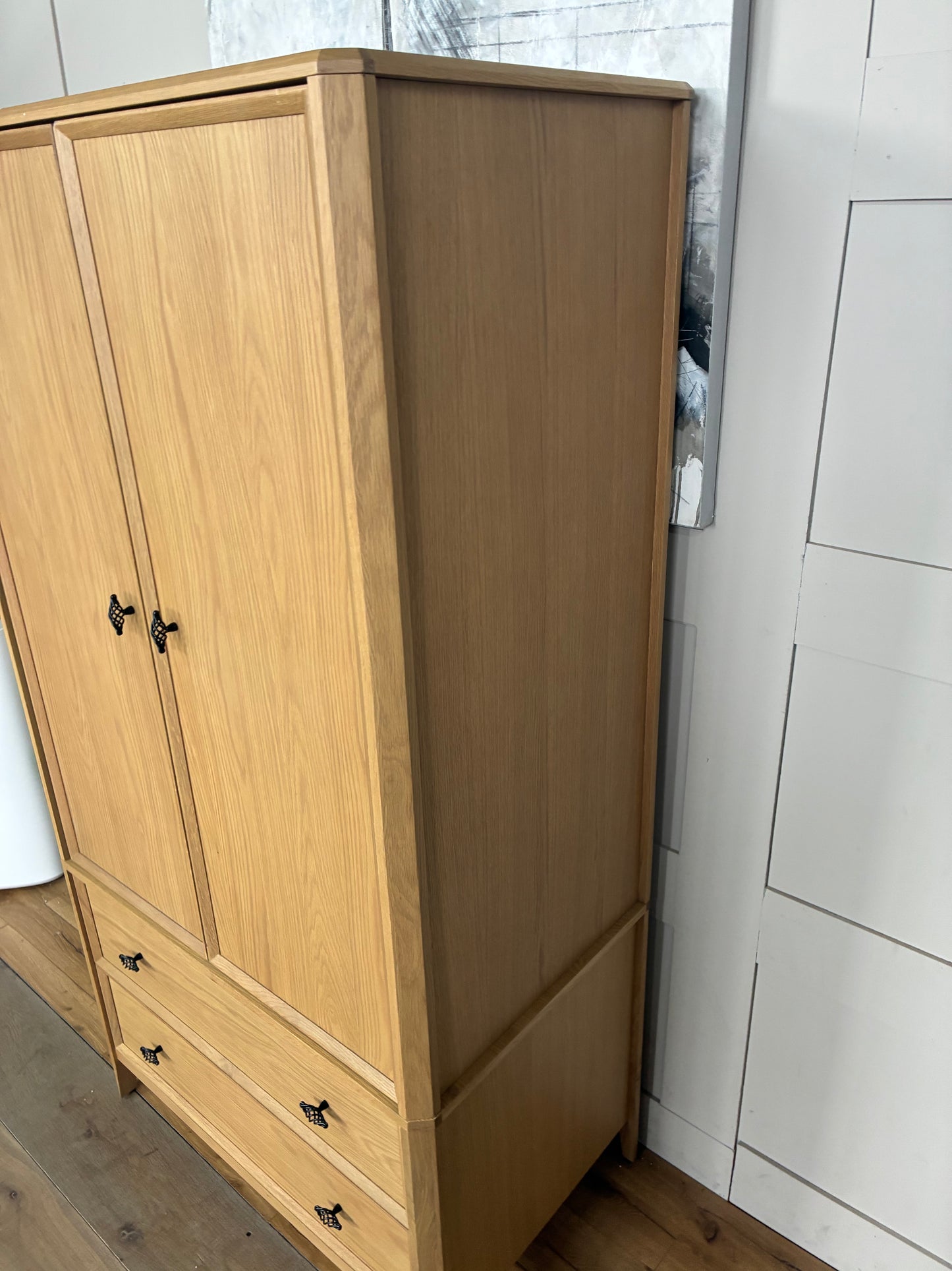Freestanding John Lewis Bevel Double Wardrobe in a natural light oak finish, featuring two hinged doors with minimalist metal handles, two spacious storage drawers at the base, and distinctive beveled detailing along the edges and plinth.