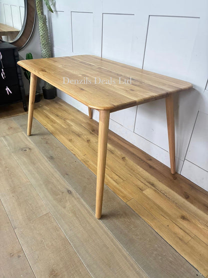 A mid-century modern style John Lewis Greenwood dining table crafted from solid oak with a light Bianco oil finish, featuring clean lines, tapered legs, and a 130cm round tabletop showcasing natural wood grain