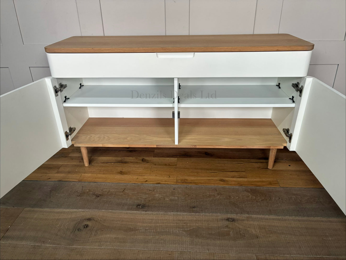 Mid-century modern inspired wide sideboard designed by Ebbe Gehl for John Lewis. The unit features two minimalist matte white cabinet doors with integrated finger-pull handles, a smooth natural oak wood top, and a matching solid oak base frame with four tapered legs