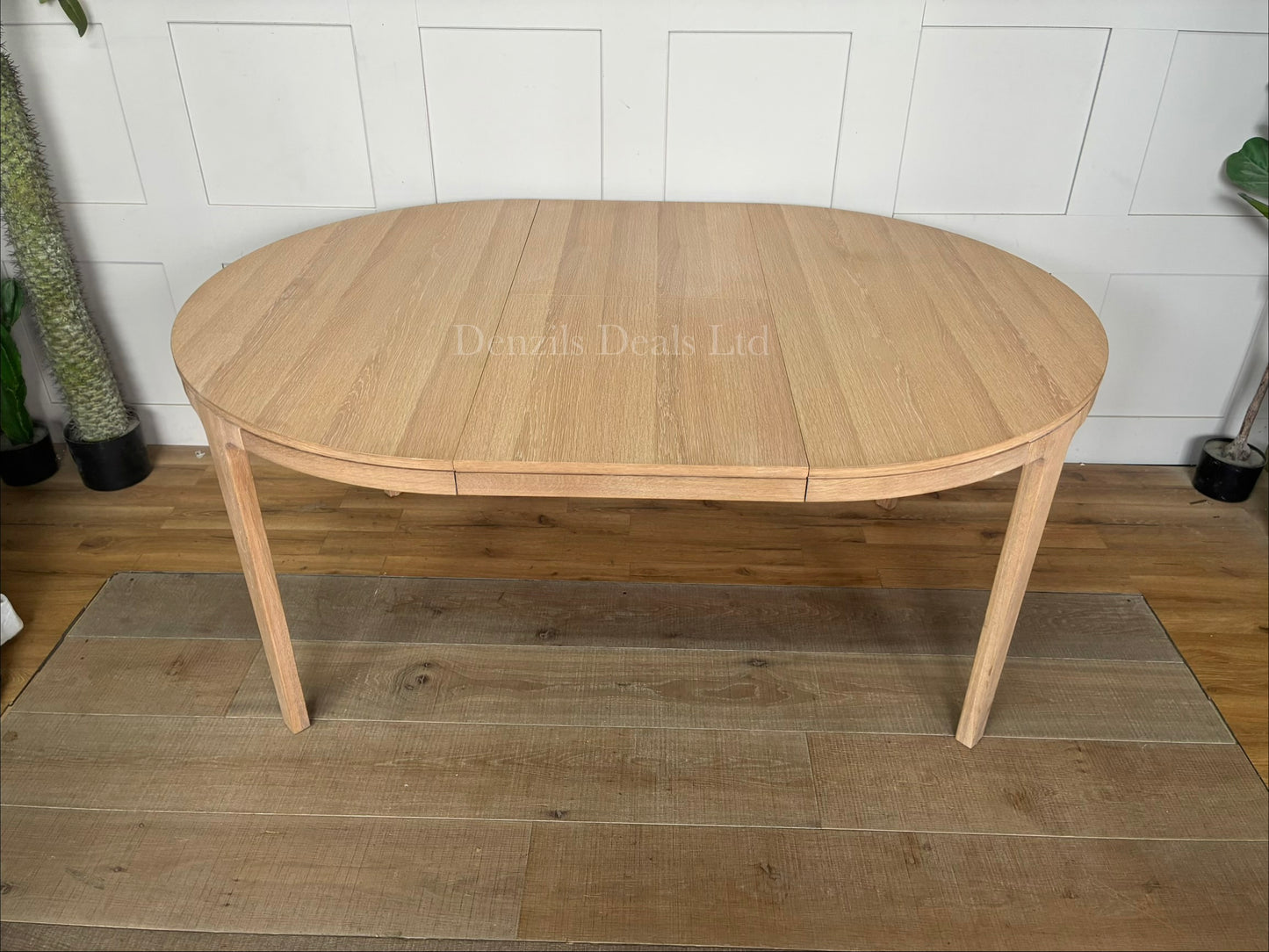 John Lewis Mira II round dining table in light oiled oak, featuring a clean Scandinavian design with tapered legs, shown in its compact unextended form