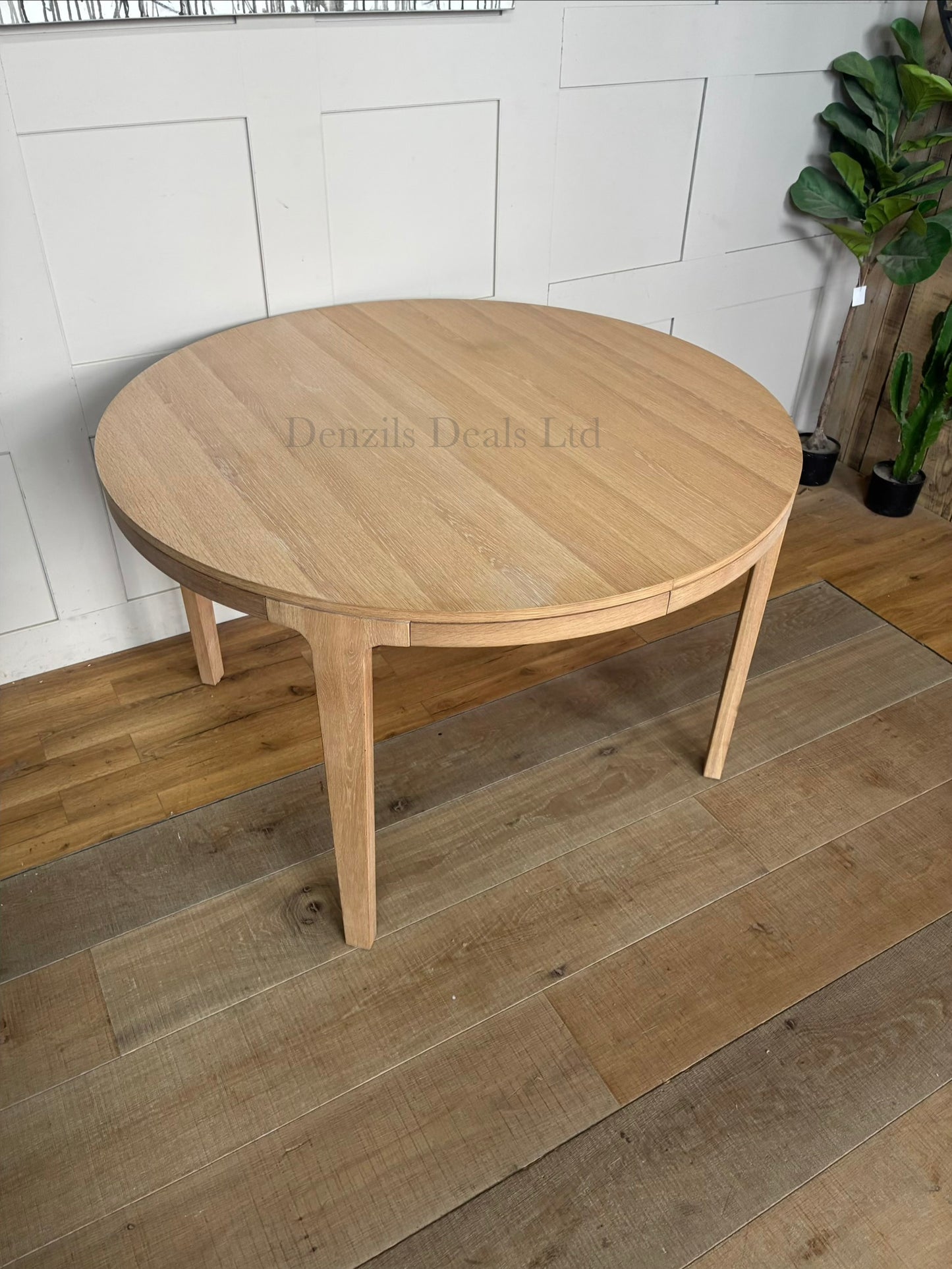 John Lewis Mira II extendable round dining table in light natural oak wood with a Scandi design.