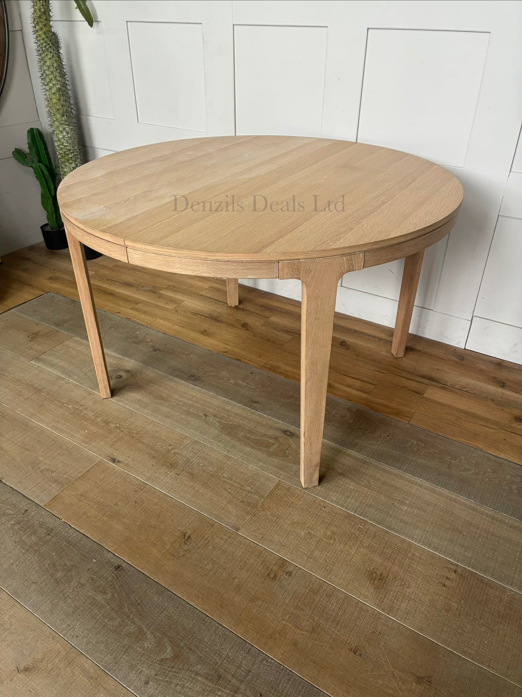 John Lewis Mira II extendable round dining table in light natural oak wood with a Scandi design.