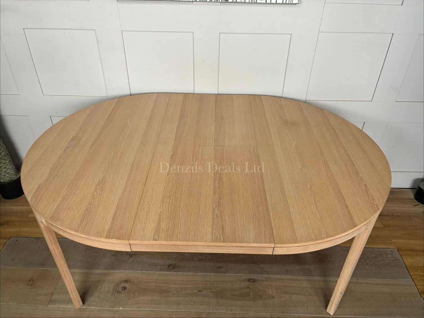 John Lewis Mira II extending oak dining table, shown fully extended into an oval shape with seating for up to six people.