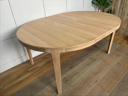 John Lewis Mira II extending round dining table made from solid oak and oak veneers.