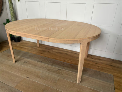 John Lewis Mira II extending oak dining table, shown fully extended into an oval shape with seating for up to six people.