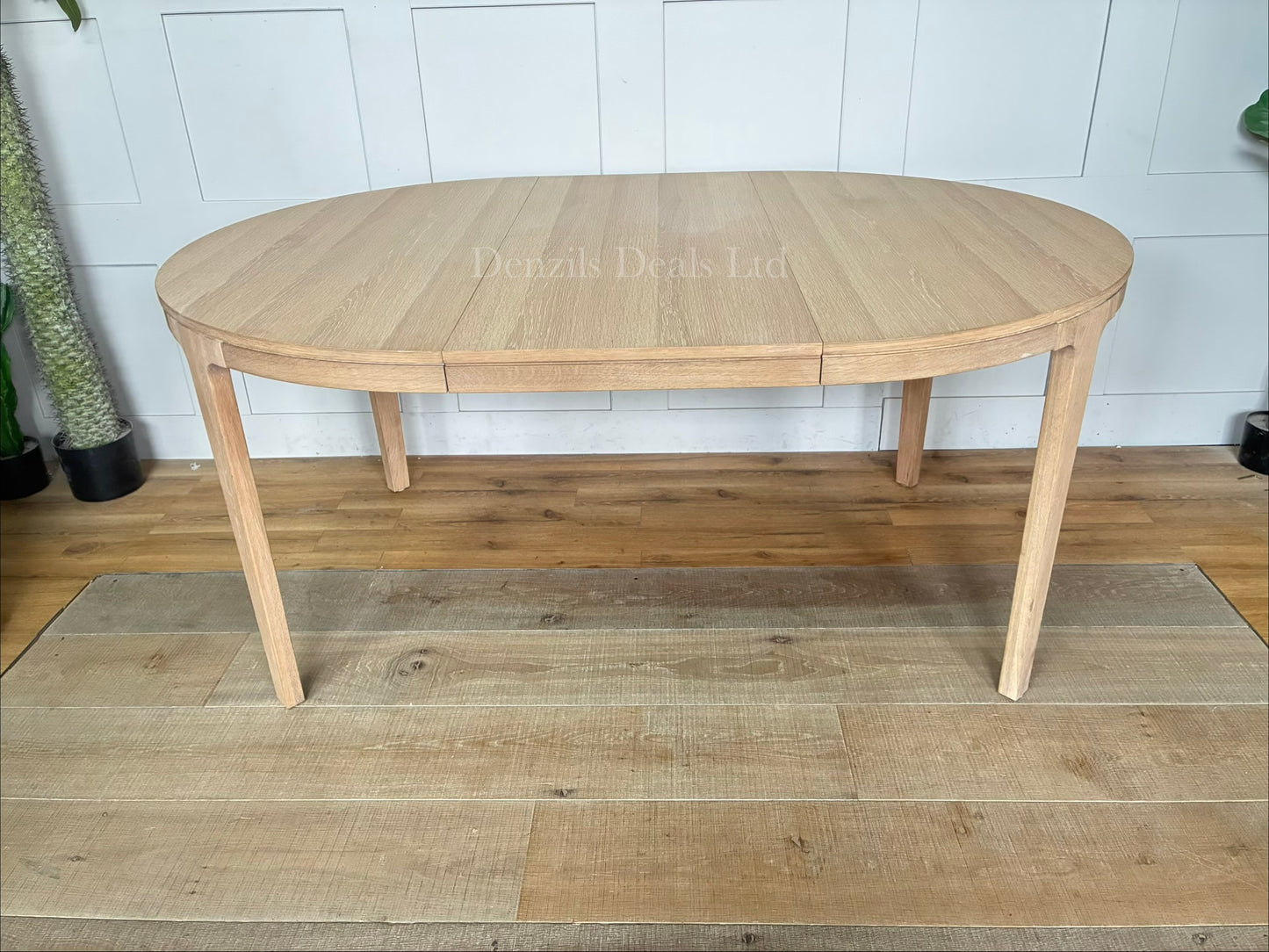 John Lewis Mira II round dining table in light oiled oak, featuring a clean Scandinavian design with tapered legs, shown in its compact unextended form