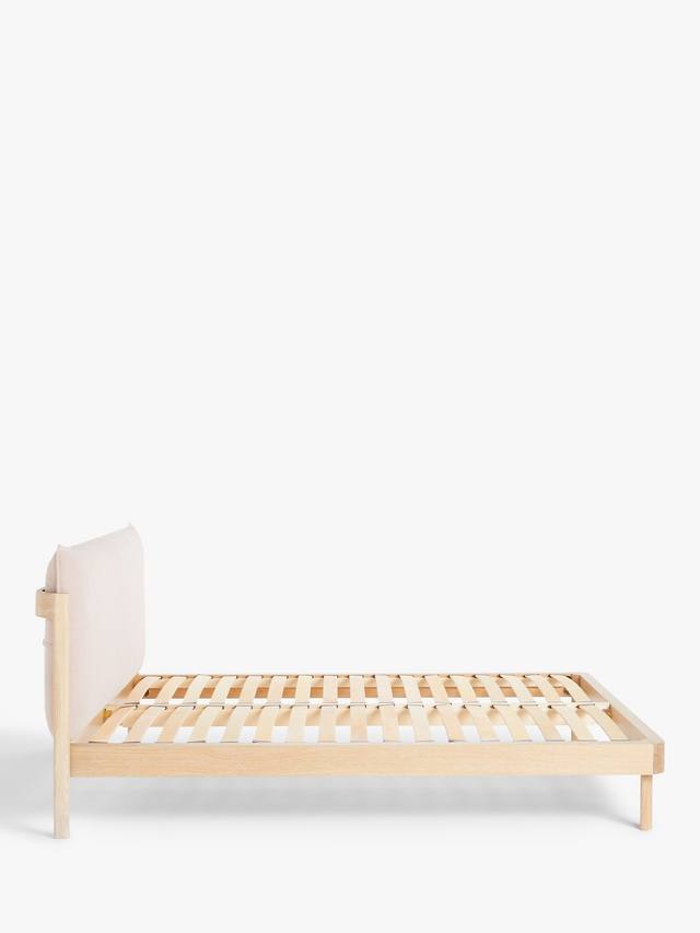 Modern double bed frame featuring a light natural oak wooden base and a soft, low-profile upholstered pillow headboard in grey fabric.