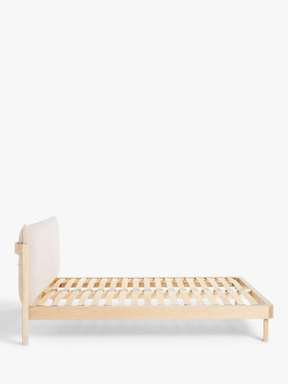 Modern double bed frame featuring a light natural oak wooden base and a soft, low-profile upholstered pillow headboard in grey fabric.