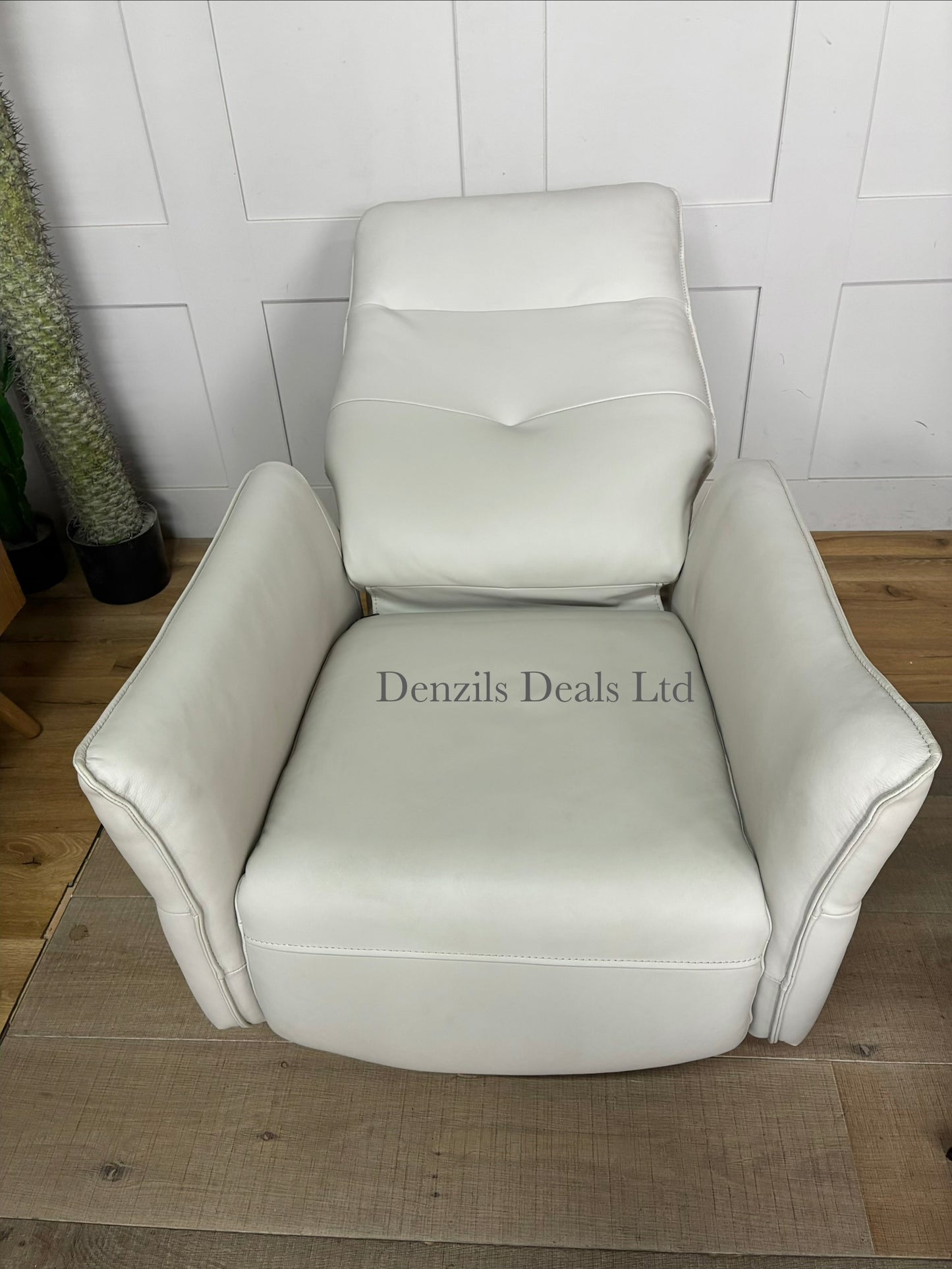 Minimalist modern interior scene featuring a John Lewis Relaxed premium leather recliner chair and footstool. The sleek, tan-coloured leather upholstery contrasts with thin metal legs, offering a refined look for a modern living space.