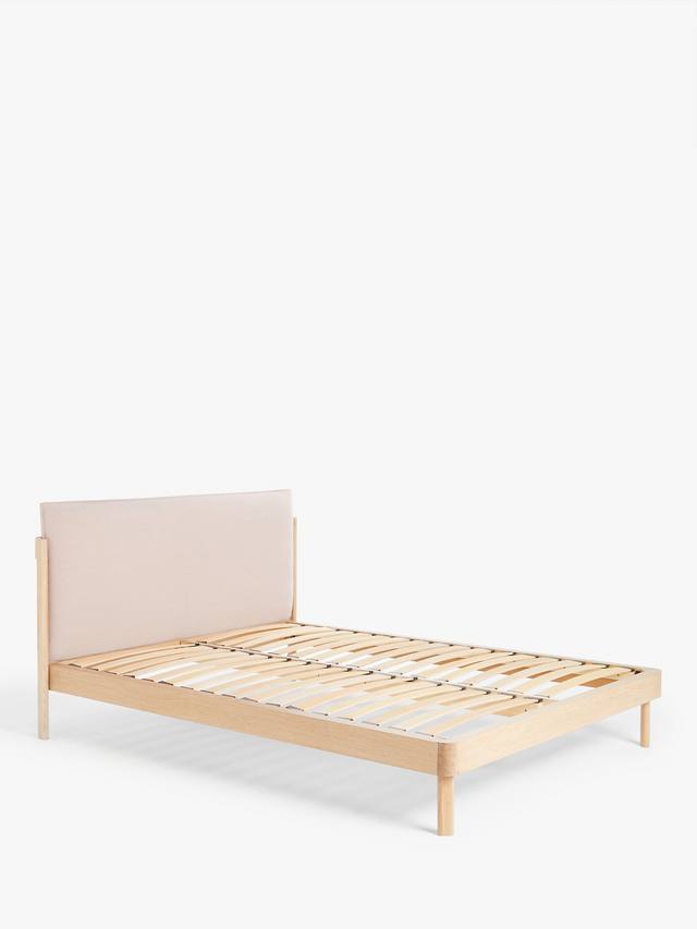 A John Lewis contemporary double bed with a natural wood frame and grey cushioned headboard, styled in a minimalist modern bedroom with white bedding.