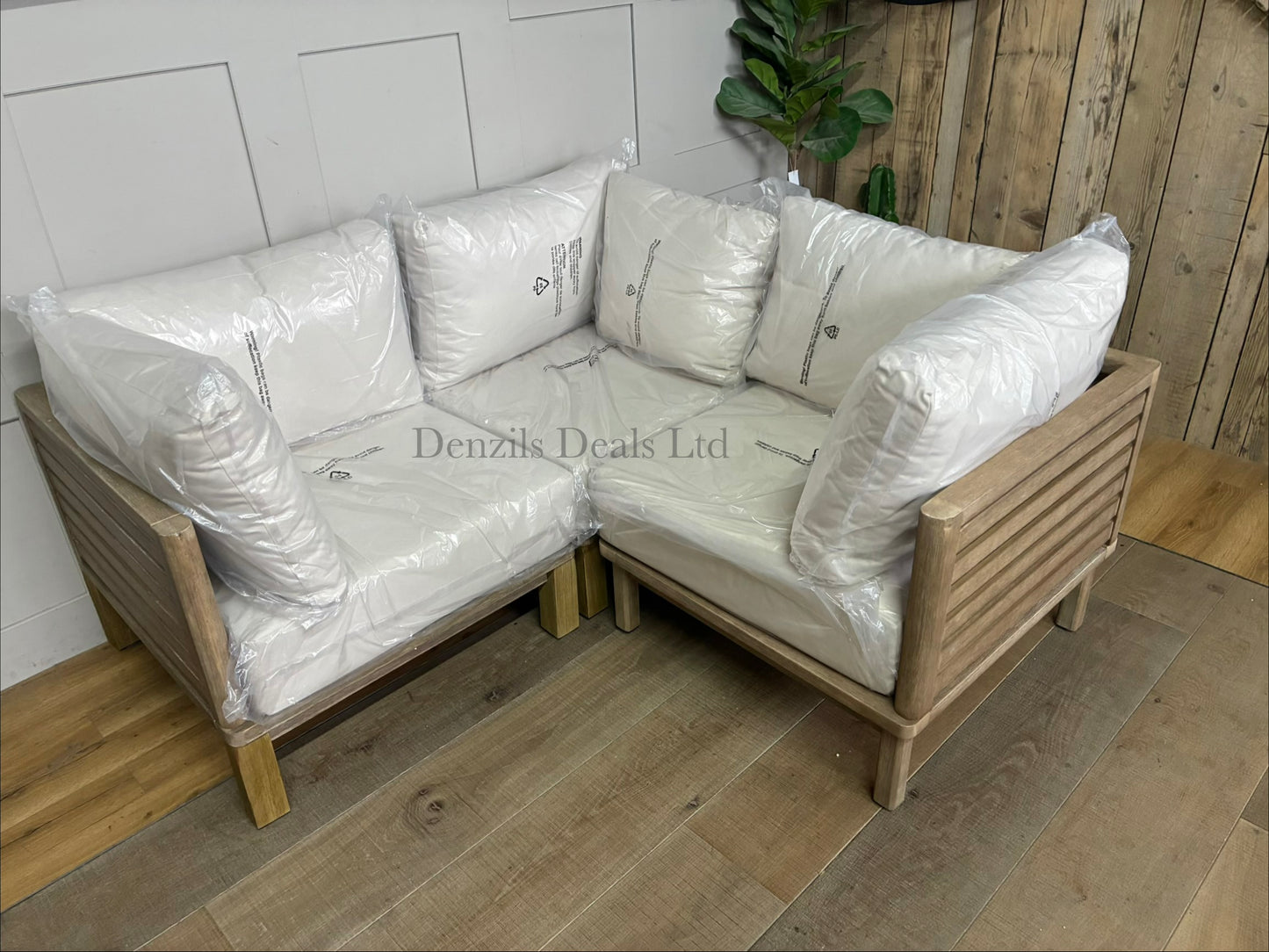 Three low-slung modular garden corner chair made from brushed eucalyptus wood with a modern slatted design and thick seat and backrest cushions, combined to make a perfect corner sofa