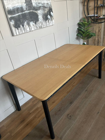 Modern rectangular dining table with a light oak wood top and contrasting matte black legs.