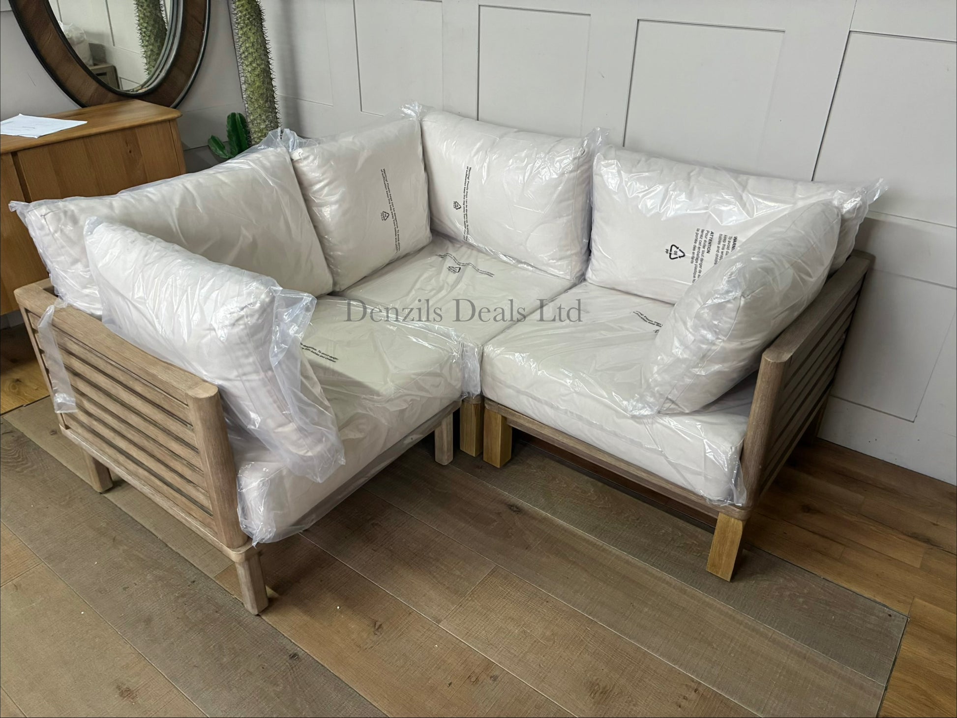 Three low-slung modular garden corner chair made from brushed eucalyptus wood with a modern slatted design and thick seat and backrest cushions, combined to make a perfect corner sofa