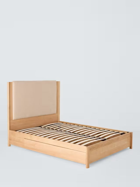 John Lewis Rest 4-drawer king-size bed frame in natural wood, featuring a solid oak frame and an upholstered padded fabric panel on the headboard
