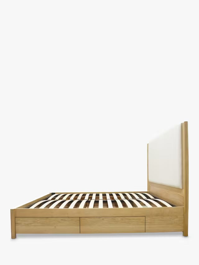 A sculpted solid oak king-size bed frame with two storage drawers on each side and a natural finish, showcasing a minimalist, refined craftsmanship style