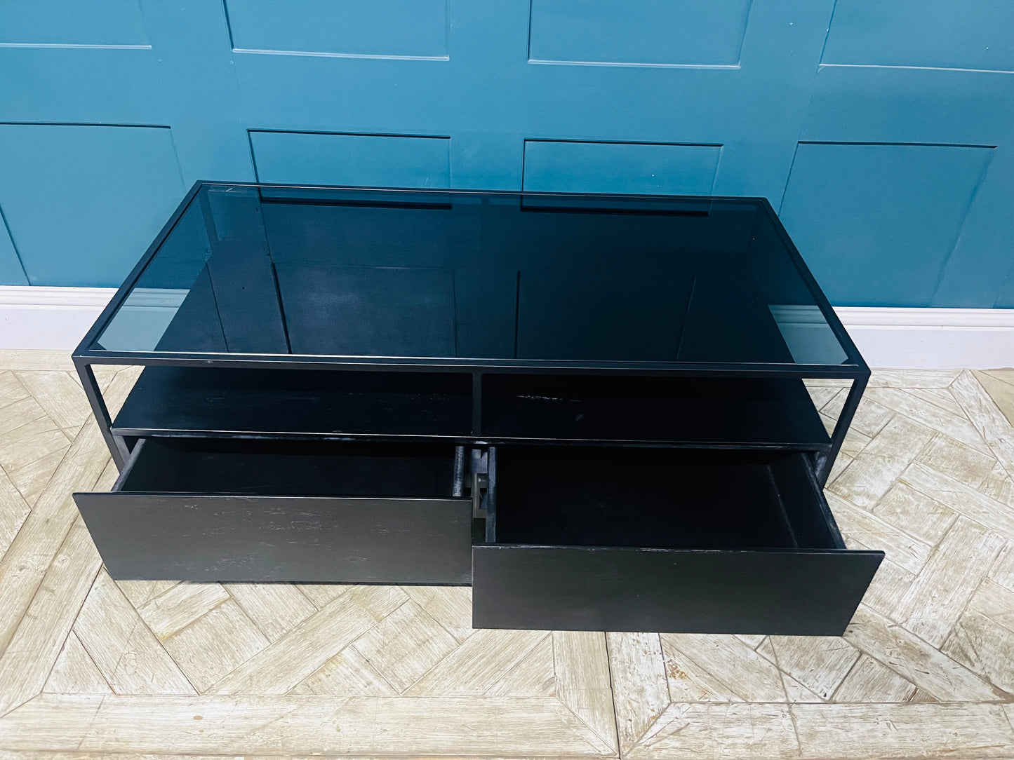 Kilby storage coffee table with two drawers, black mango wood base, and smoked glass surface. Metal frame legs