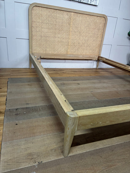 King-size Loaf Ribbon bed frame crafted from light natural oak wood, featuring a clean-lined, Scandi-inspired headboard with woven rattan detailing.