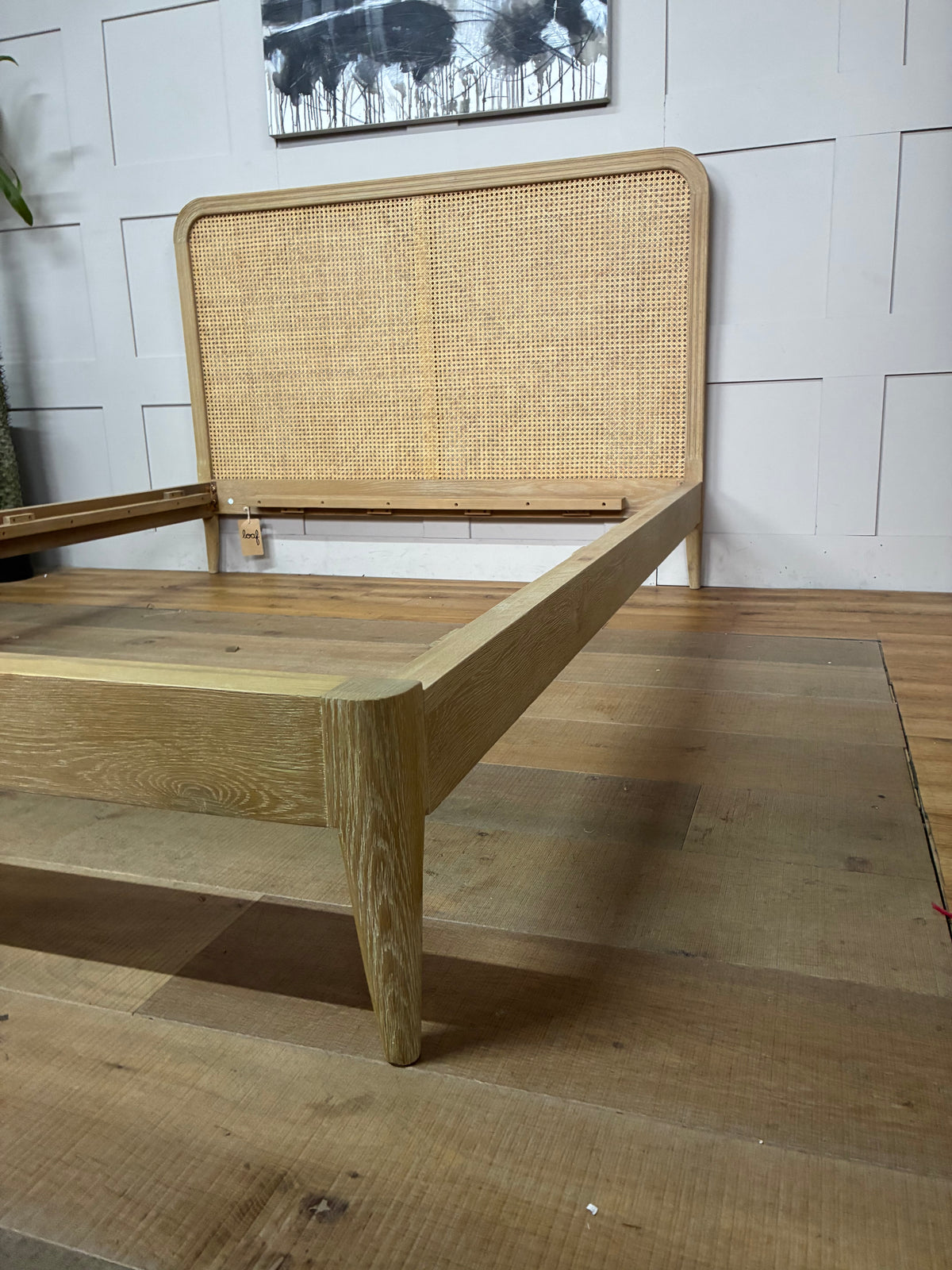 King-size Loaf Ribbon bed frame crafted from light natural oak wood, featuring a clean-lined, Scandi-inspired headboard with woven rattan detailing.