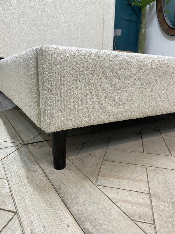 King size Doddington bed with textured ivory boucle upholstery and curved winged headboard.