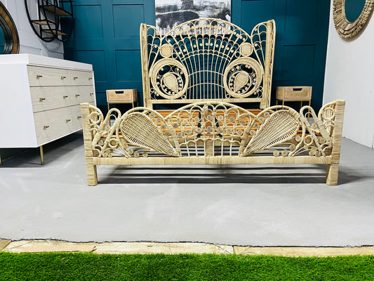 King size Kinsella rattan bed with a natural finish, featuring a high, fan-shaped headboard with intricate feminine filigree weaving and a powder-coated steel frame