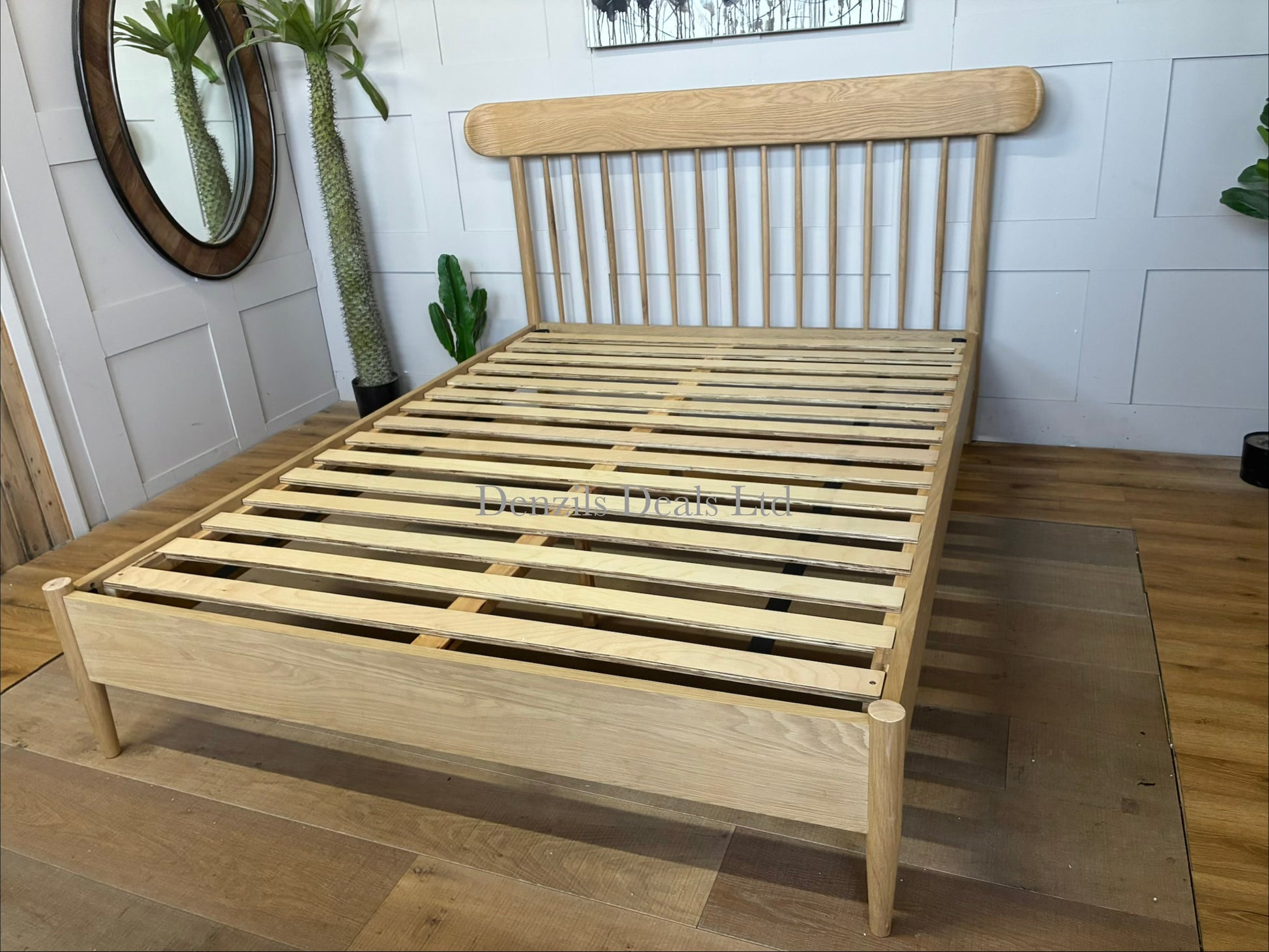 King size wooden bed frame in natural oak with a classic spindle headboard and footboard by Gallery Direct.