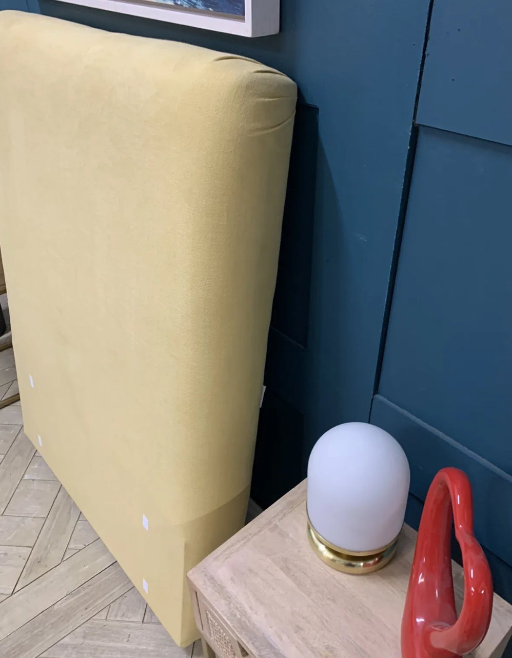 An upholstered single bed headboard by Loaf in a pale yellow 'Lemon Drizzle' brushed cotton fabric. The design has a smooth, simple curved top with no buttons, studs, or piping.