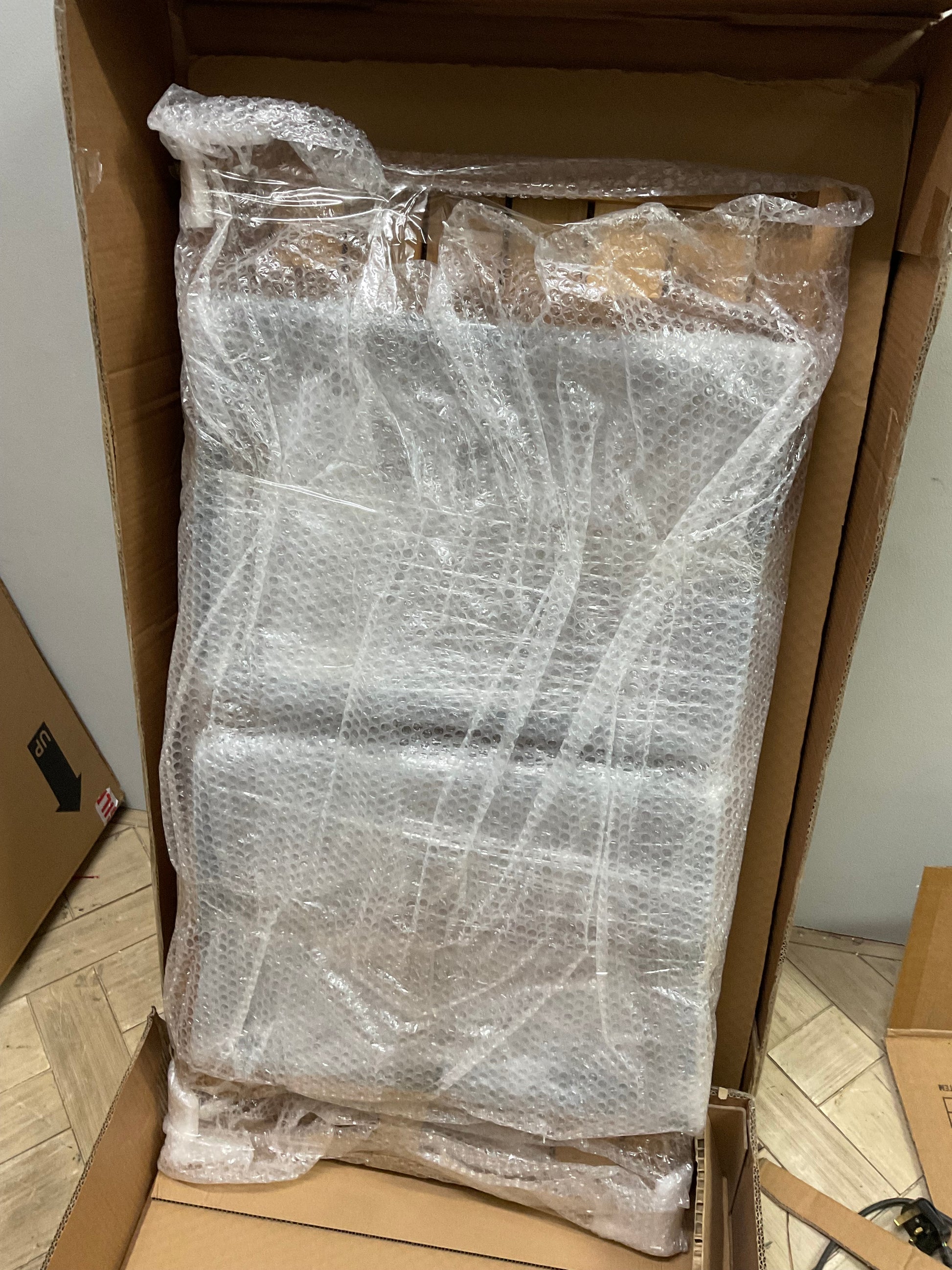 Made.com Topa garden armchair and low coffee table set in solid acacia wood with charcoal grey cushions on a patio.