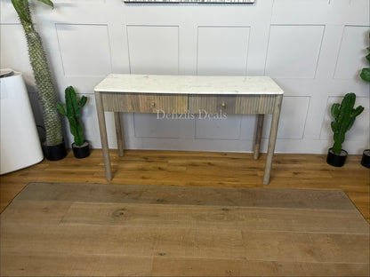 Marmo Marble Top 2 Drawer Console Table with a polished white Indian Carrera marble surface with unique grey and blue veining, Crafted from solid mango wood with a grey-wash finish, two drawers feature striking vertical ribbed textures that provide architectural depth. Finished with elegant round button knobs, typically in brass or gold-toned metal