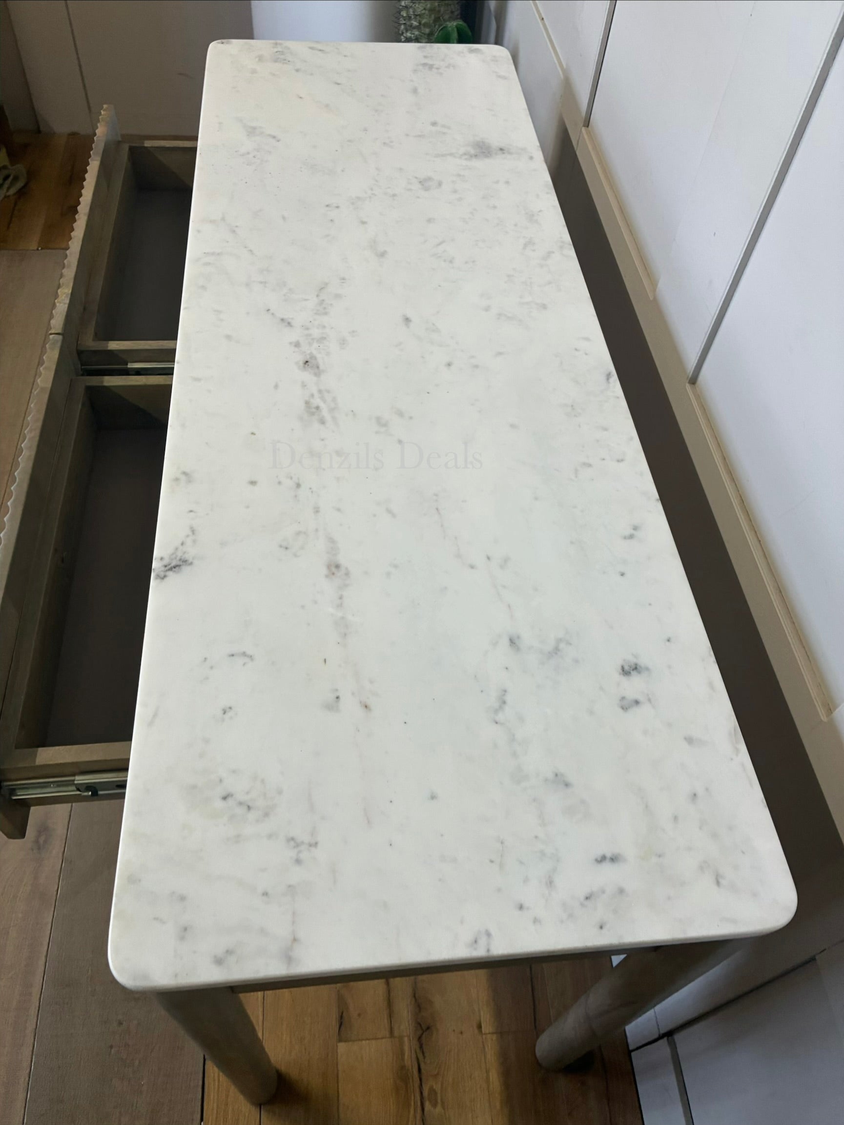 Marmo Marble Top 2 Drawer Console Table with a polished white Indian Carrera marble surface with unique grey and blue veining, Crafted from solid mango wood with a grey-wash finish, two drawers feature striking vertical ribbed textures that provide architectural depth. Finished with elegant round button knobs, typically in brass or gold-toned metal