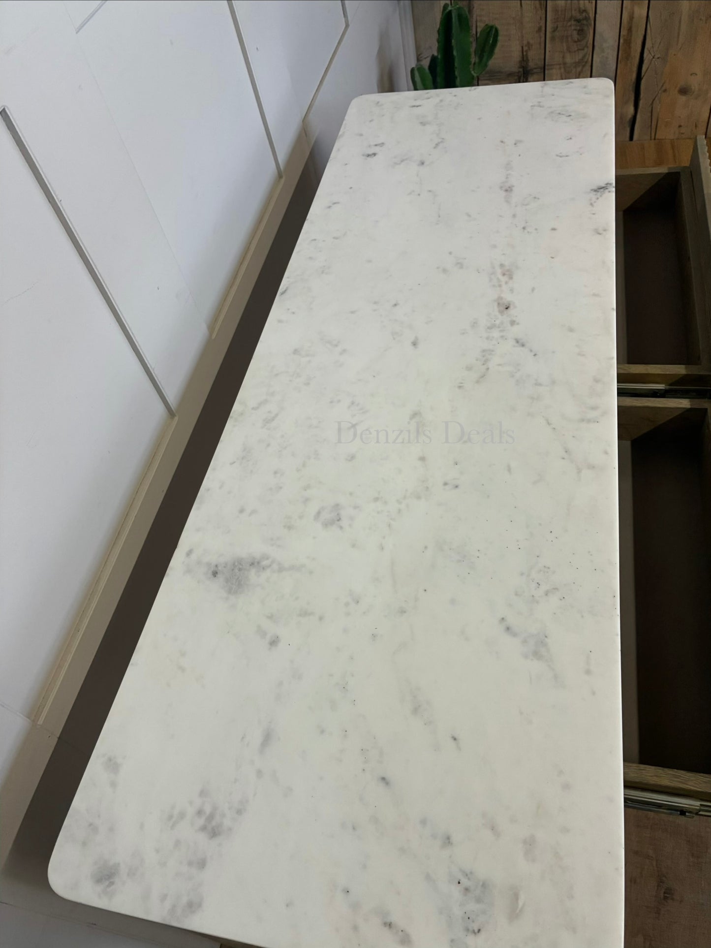 Marmo Marble Top 2 Drawer Console Table with a polished white Indian Carrera marble surface with unique grey and blue veining, Crafted from solid mango wood with a grey-wash finish, two drawers feature striking vertical ribbed textures that provide architectural depth. Finished with elegant round button knobs, typically in brass or gold-toned metal