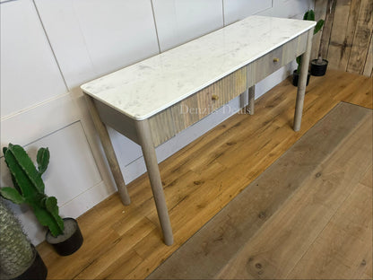 Marmo Marble Top 2 Drawer Console Table with a polished white Indian Carrera marble surface with unique grey and blue veining, Crafted from solid mango wood with a grey-wash finish, two drawers feature striking vertical ribbed textures that provide architectural depth. Finished with elegant round button knobs, typically in brass or gold-toned metal
