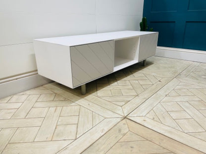 Media console by Content by Terence Conran in white with a geometric diagonal pattern on the doors and exposed wooden legs
