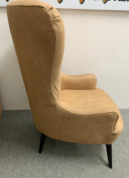 Mid-century modern Bodil accent chair in tan leather styled in a minimalist living room