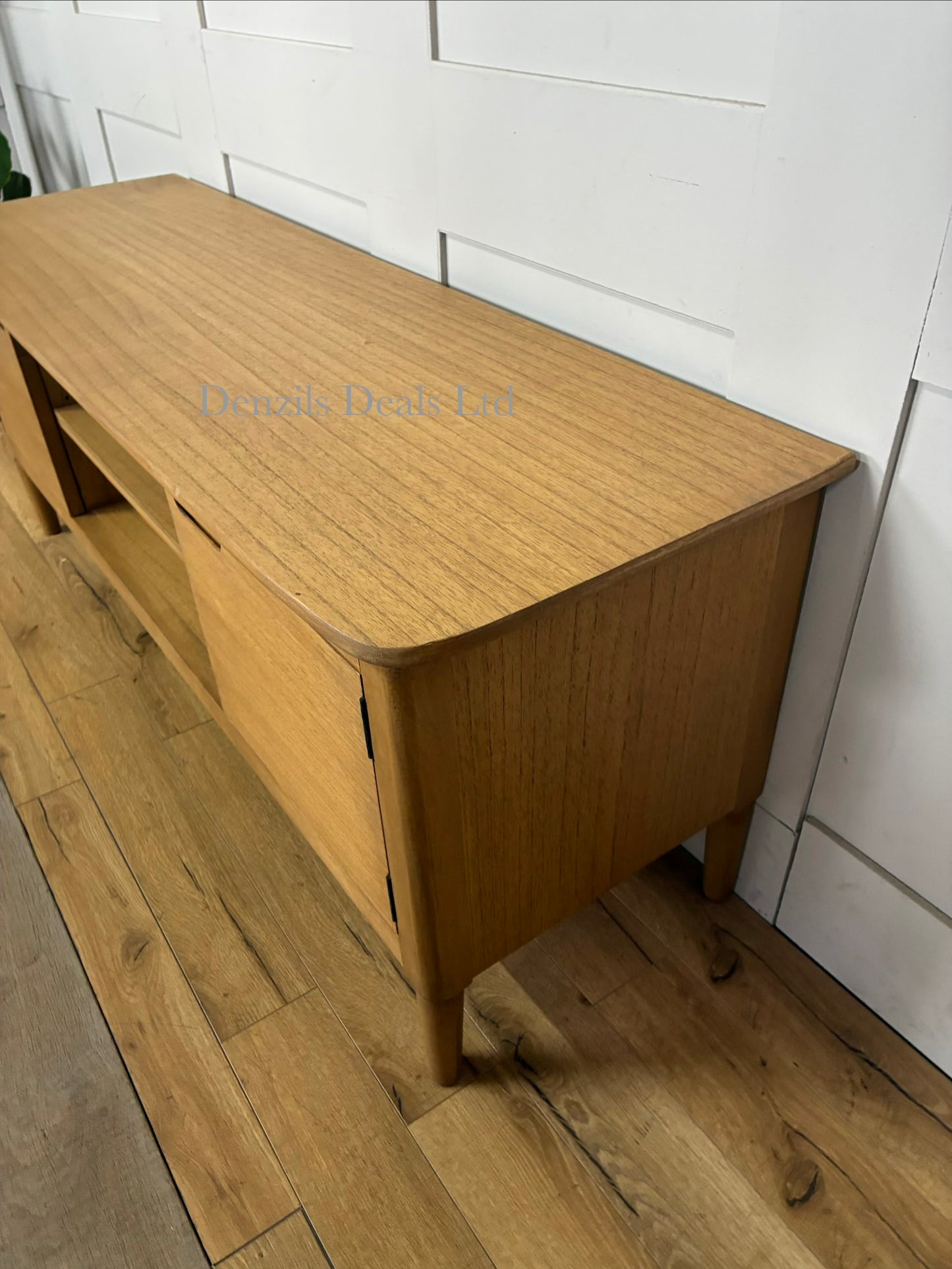 Mid-century modern Norway Oak TV Stand by Fishe and Lilly, featuring a warm natural wood grain, central open shelving, side cabinets, and tapered legs