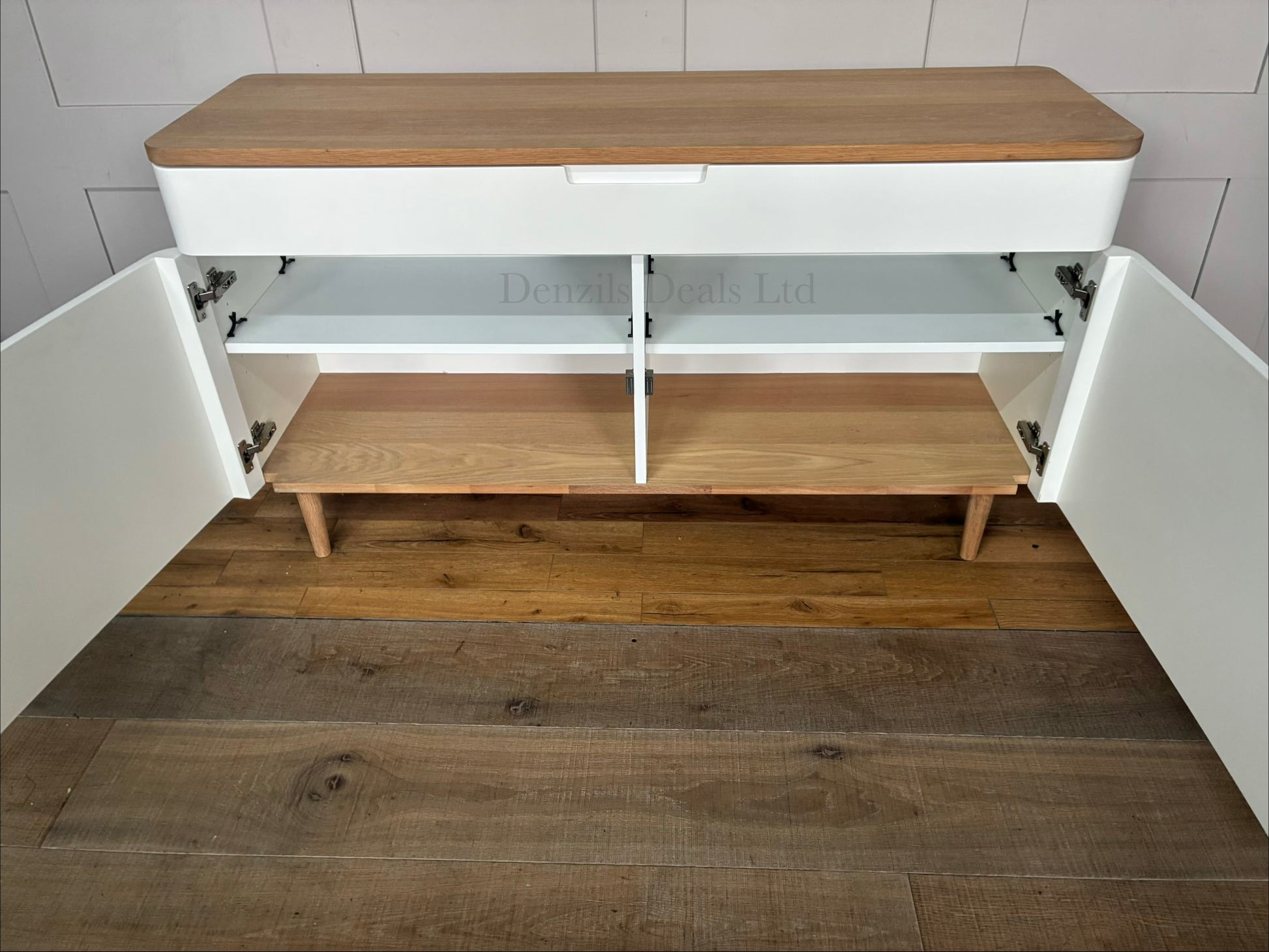 Mid-century modern inspired wide sideboard designed by Ebbe Gehl for John Lewis. The unit features two minimalist matte white cabinet doors with integrated finger-pull handles, a smooth natural oak wood top, and a matching solid oak base frame with four tapered legs