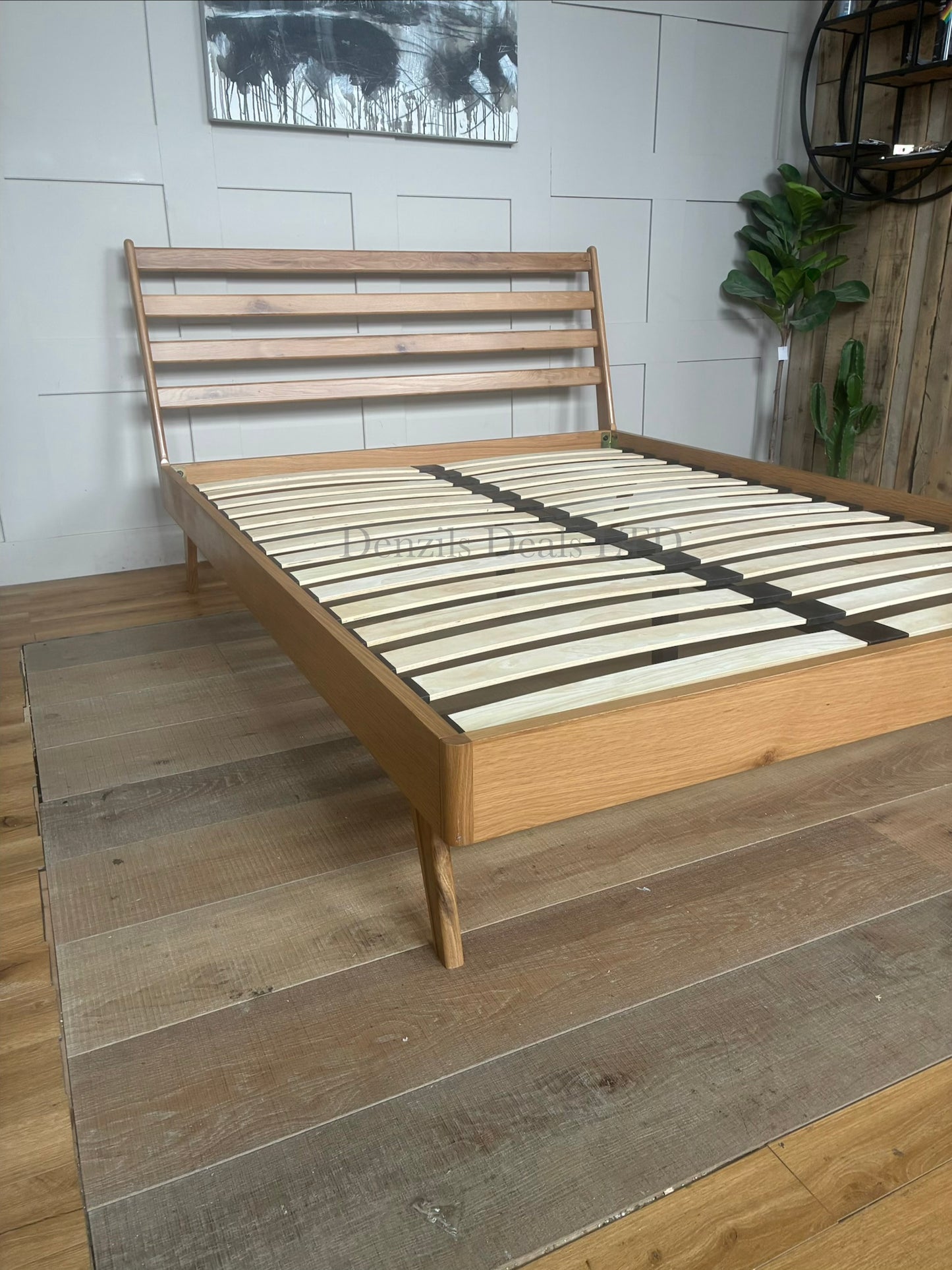 Mid-century modern king-size bed frame from the John Lewis X-Ray collection, featuring a sturdy oak wood frame, tapered legs, and a padded upholstered headboard in mandarin orange fabric with a smooth, curved silhouette.