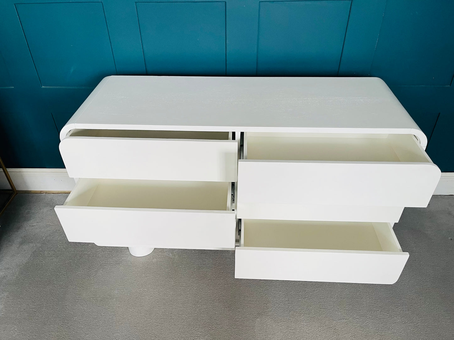 Minimalist white wooden 6-drawer dresser with a modern curved silhouette.