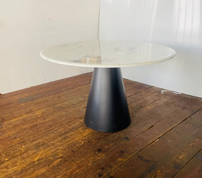 Modern Richmond Degas 120cm circular dining table. The table features a smooth, polished white faux-marble top with subtle grey veining, supported by a minimalist black stainless steel leg frame. 