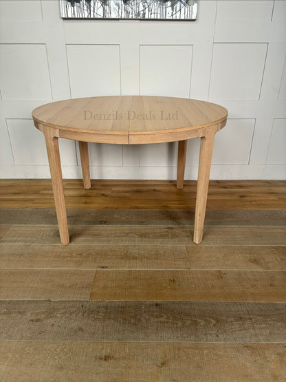 Modern dining room featuring the John Lewis Mira II round oak dining table surrounded by matching chairs on a neutral rug.