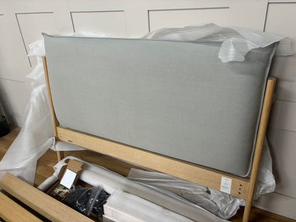 Modern double bed frame featuring a light natural oak wooden base and a soft, low-profile upholstered pillow headboard in grey fabric