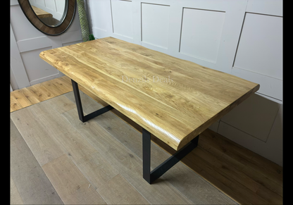 Modern industrial dining room setting featuring the Oak Furnitureland Brooklyn 8-seater dining table. The table showcases a solid natural oak tabletop with distinctive wood grain patterns and curved, wavy live edges, supported by dark, industrial-style metal legs