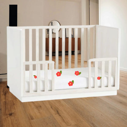 Modern low-profile wooden baby cot by West Elm and Pottery Barn Kids showing the toddler bed conversion kit installed