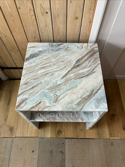 Modern minimalist cube side table crafted from solid natural marble with distinct grey veining. The table features an open, hollow center with thick marble slabs forming the top, sides, and base, offering a clear view through the open sides