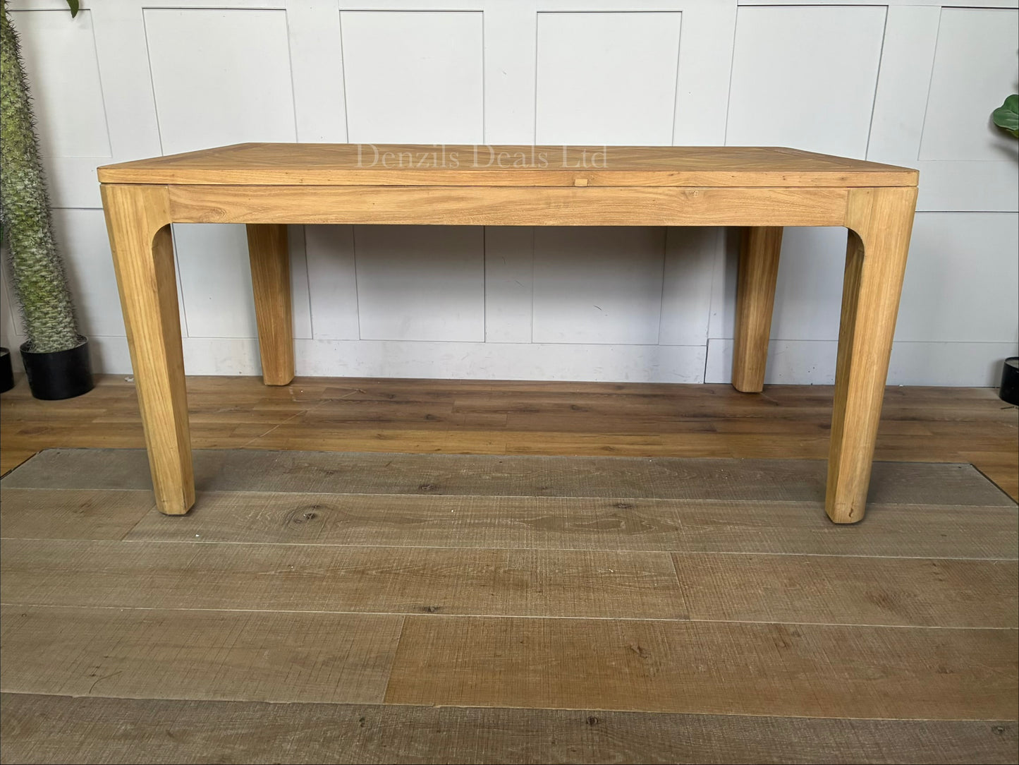 Modern minimalist dining room featuring the Ruth reclaimed solid teak table, styled with matching wooden chairs and natural light highlighting the grain patterns on the tabletop.