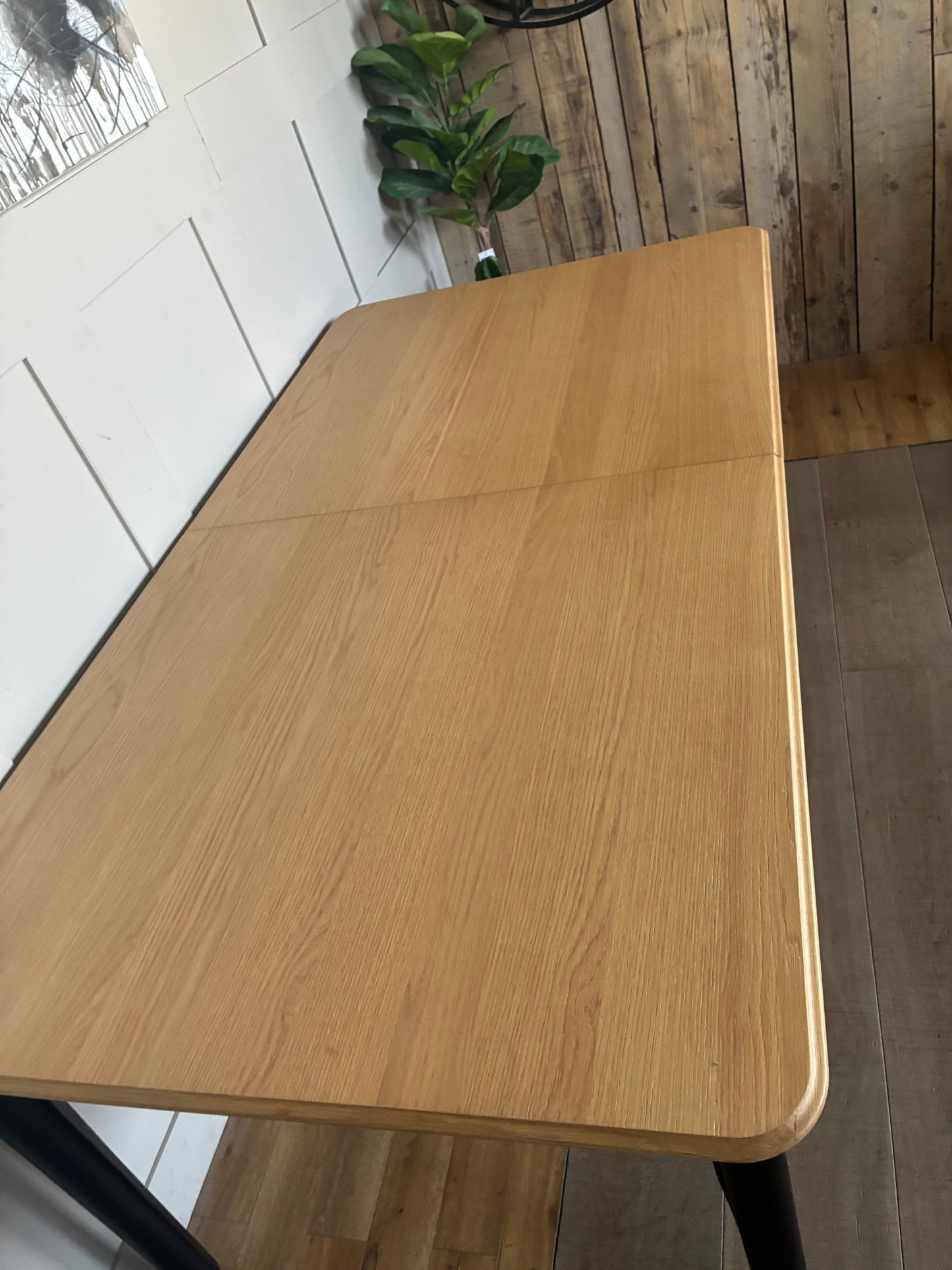 John lewis Modern rectangular dining table with a light oak wood top and contrasting matte black legs.