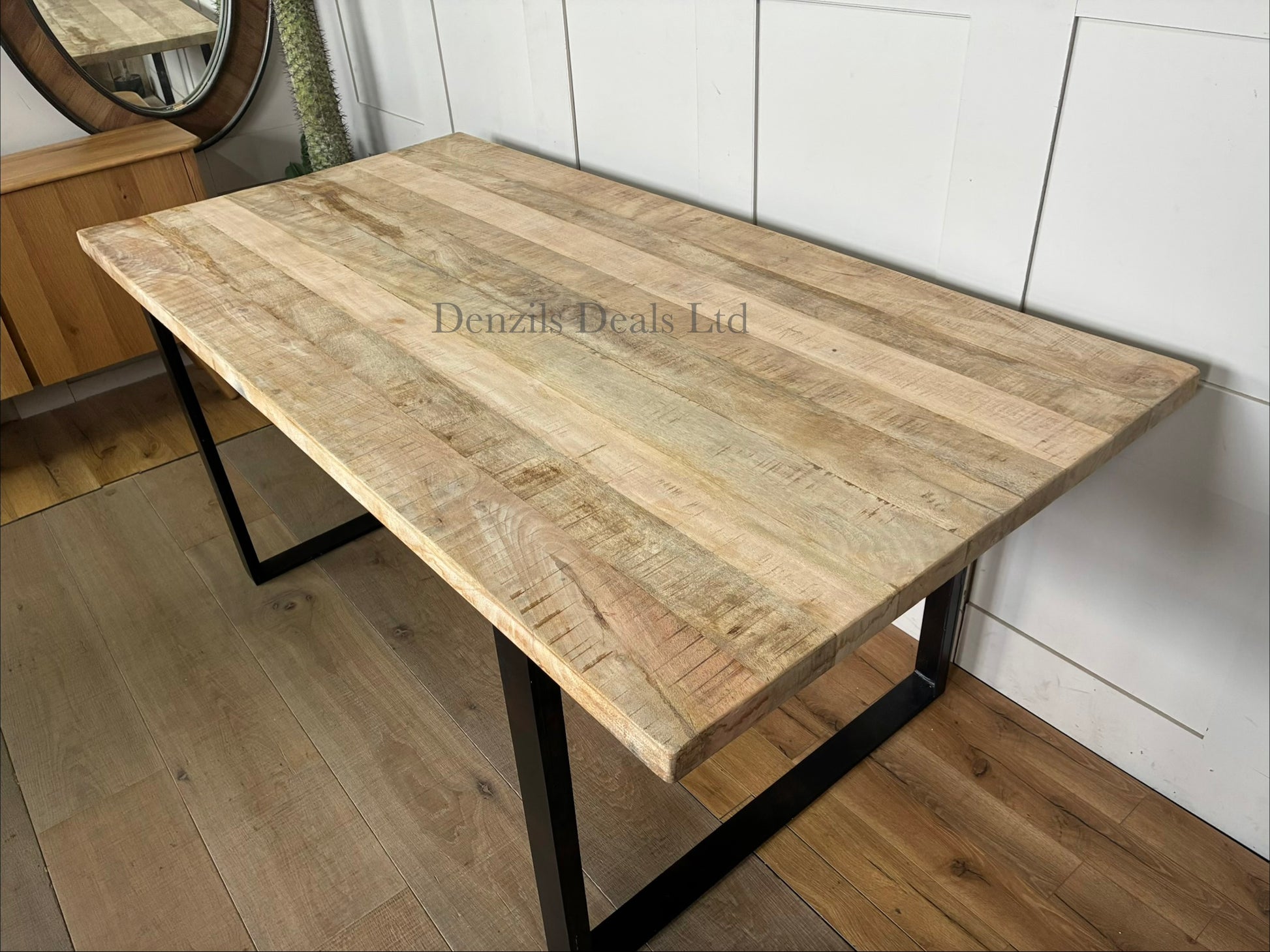 Modern rustic dining room featuring the Nkuku Fia 6-seater mango wood table surrounded by dining chairs in a brightly lit space.