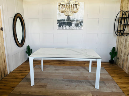 Modern white rectangular dining table with a smooth ceramic top and a lacquered metal frame, seating up to 6 people.